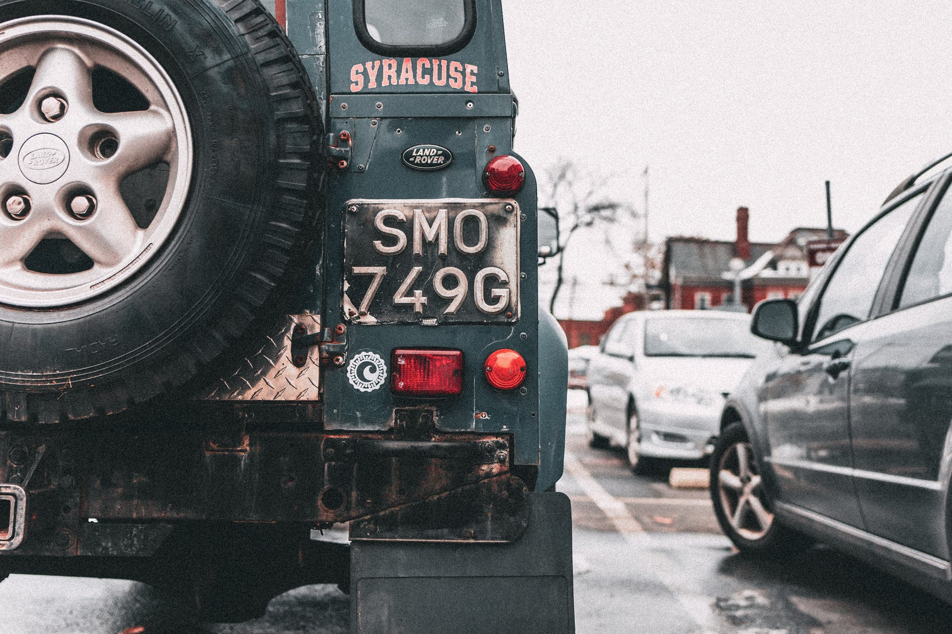 black vehicle parks near house under white sky